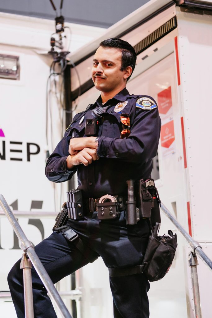 Portrait of a smiling policeman in uniform standing confidently outdoors.
